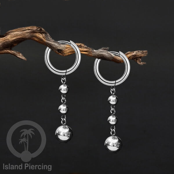 Anting hoop baja dengan liontin bola baja tersedia dalam warna silver atau gold.