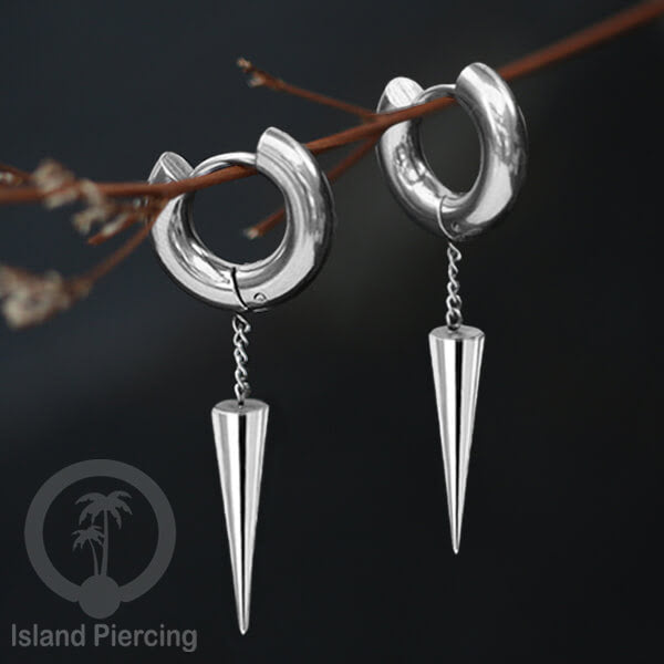 Anting hoop baja dengan liontin paku baja tersedia dalam warna silver atau gold.