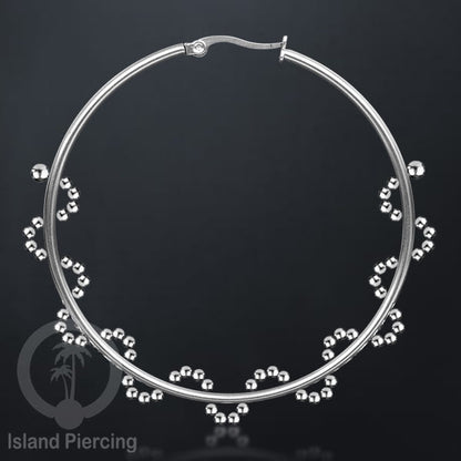 Anting hoop stainless steel 60mm yang dihiasi dengan bola-bola baja kecil dan batu asli.