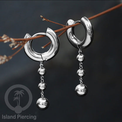 Anting hoop baja dengan liontin bola baja tersedia dalam warna silver atau gold.