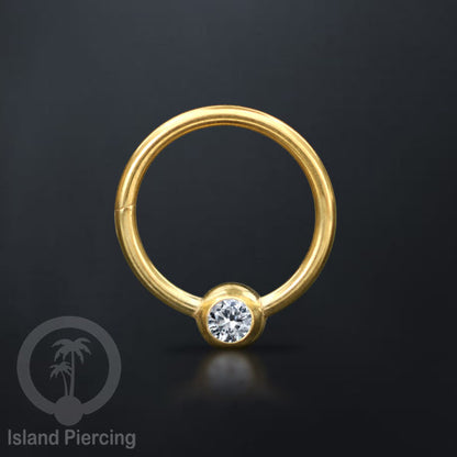Hinged Segment Ring warna gold dengan batu di pakai dalam mulut bawah bibir atas.