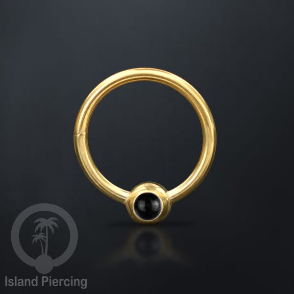 Hinged Segment Ring warna gold dengan batu di pakai dalam mulut bawah bibir atas.